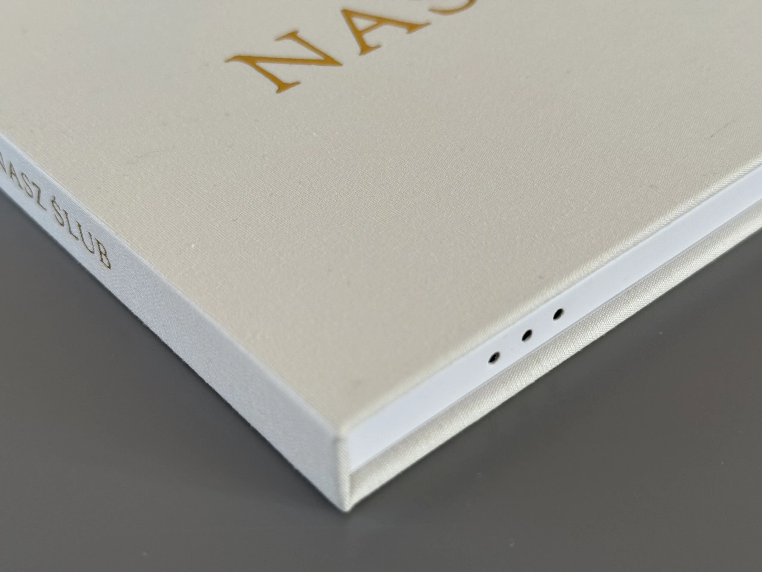 Zbliżenie na twardą lnianą okładkę oraz głośnik video albumu nasz ślub w wersji premium